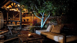 Un espace extérieur aménagé en terrasse, avec une table en bois, un banc et un canapé.