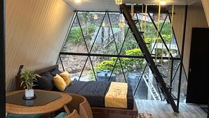 Een modern interieur met een geometrisch raamontwerp, een trap en een kroonluchter.