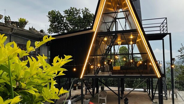 Een modern gebouw met een driehoekige gevel, een geruit vloertapijt en een schaakbord in het midden.