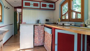 Una cocina compacta con armarios de madera, un refrigerador y una ventana que proporciona luz natural.