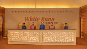 A reception desk with a sign reading "White Rann The Tenet City" and four staff members seated behind it. - White Rann - The Tent City (Dholavira)