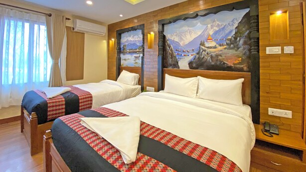 A hotel room with two beds, a large mural of a mountain landscape, wooden paneling, and a window with curtains. - Hotel Insta (Kathmandu)