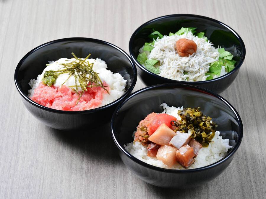 Three bowls of rice with different toppings.