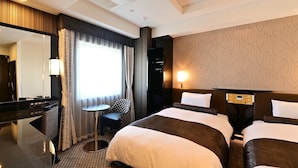 Une chambre d’hôtel avec un grand lit, un bureau, une chaise, une télévision et une lampe.
