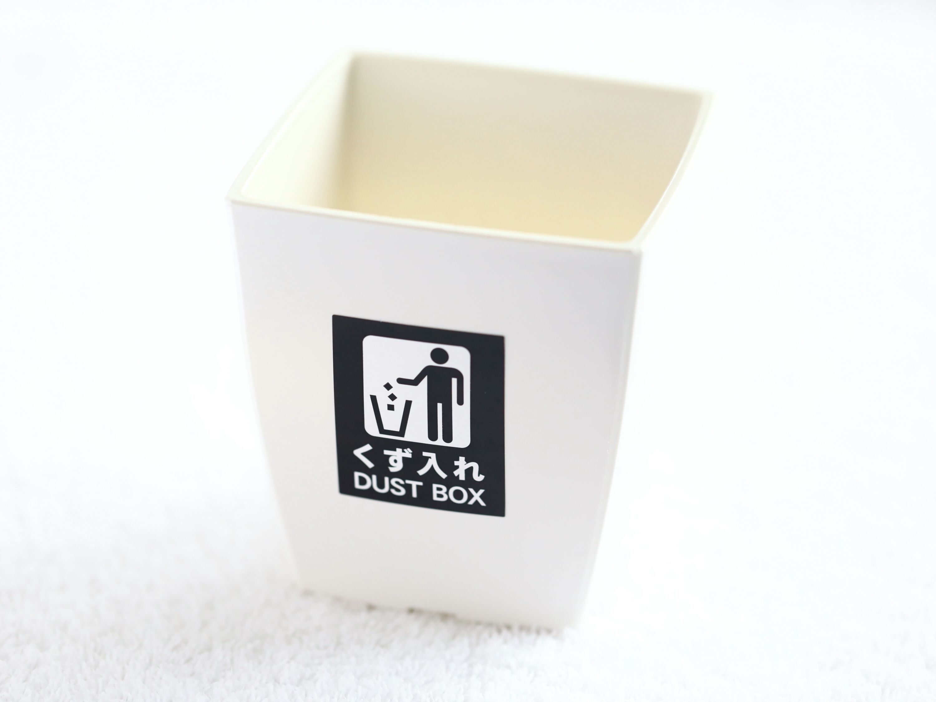 A white dust box with a black label indicating it is for dust disposal.