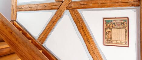 A wooden staircase with a white ceiling and framed pictures.