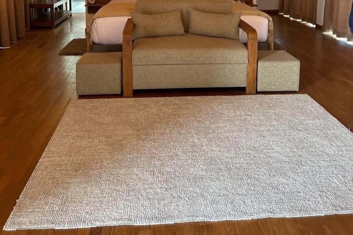 Ein geräumiges Schlafzimmer mit einem großen Bett, einem Holzkopfteil und einem Kruzifix an der Wand.