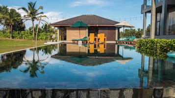 Alberca al aire libre, sombrillas en la alberca y camastros