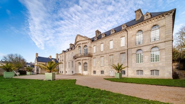 A large, historic stone building with a symmetrical facade, multiple windows, and a central entrance. - The Hôtel de Beaumont carriages (Valognes)