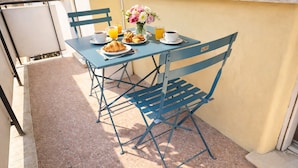 A table with chairs, breakfast items, and a flower vase. - Nestop Colli Albani (Rome)