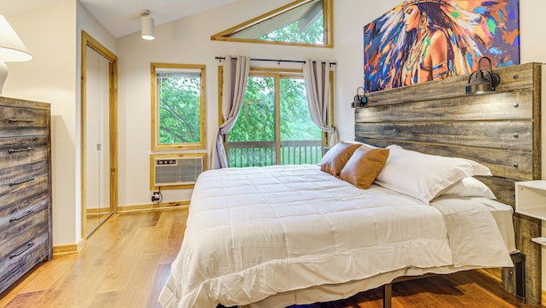 Ein Schlafzimmer mit einem großen Bett, einem Holzkopfteil und einem Bild darüber.