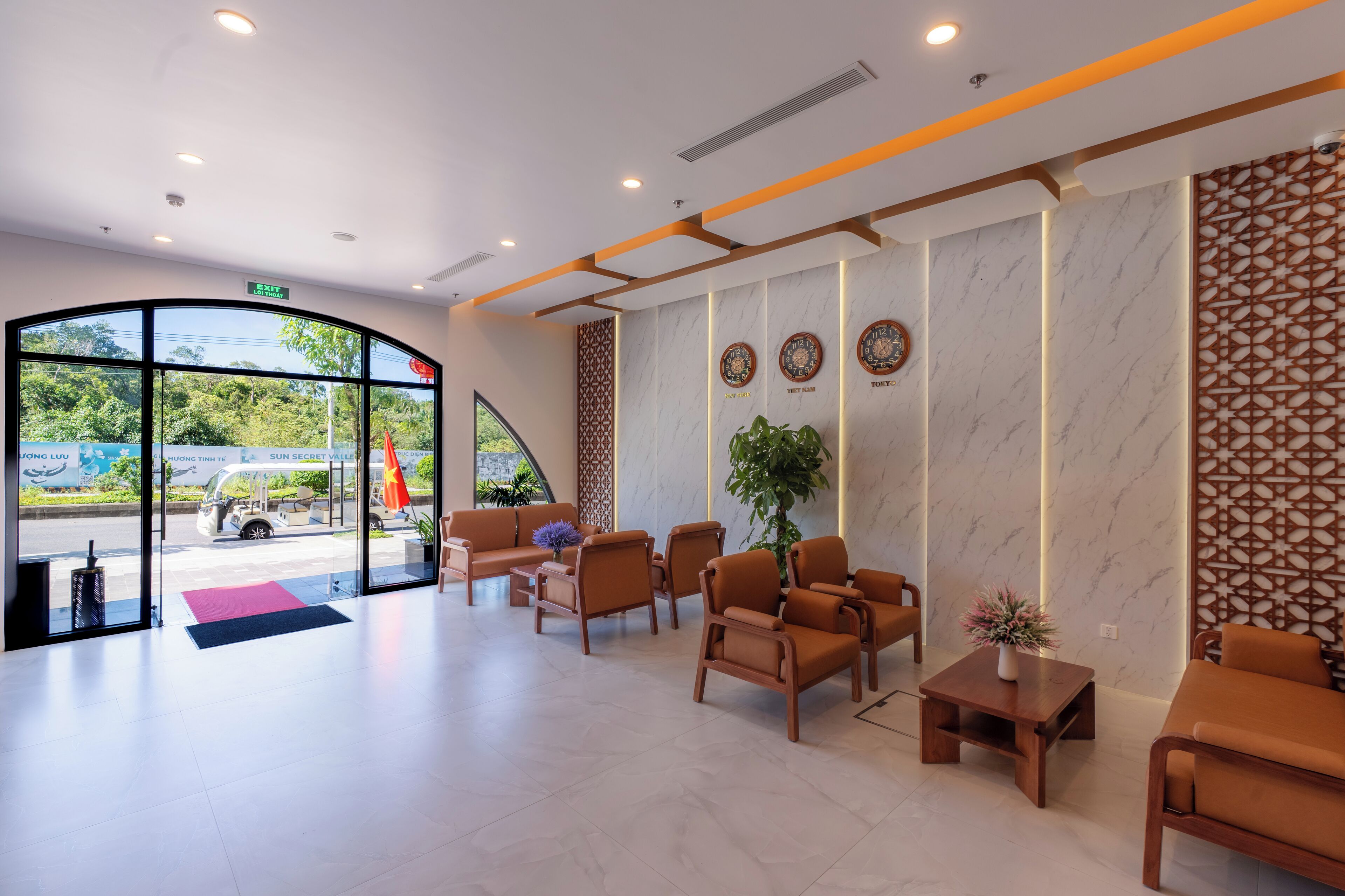 A modern lobby with seating, a reception desk, and a view of the outside.
