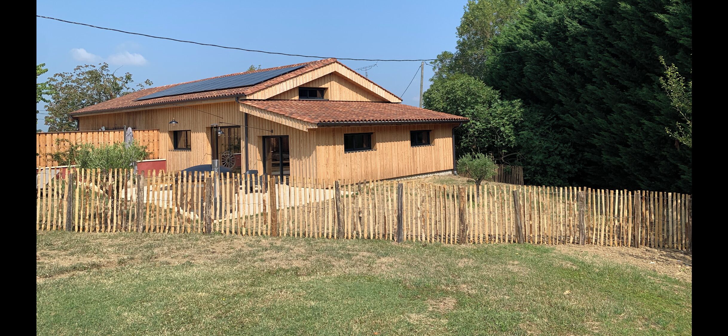 Ein Holzhaus mit geneigtem Dach und Solaranlage.