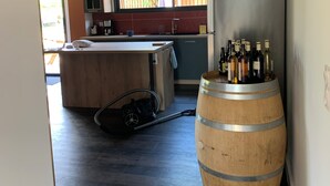 A modern kitchen with a wooden island, a large window, and a wine barrel. - Gîtes Barns de la Truffière : Loft Coté Grange (Monbazillac)