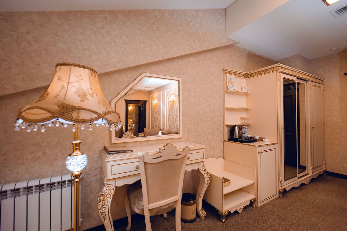 Une pièce comprenant une coiffeuse, un miroir, une lampe, une chaise et une armoire.