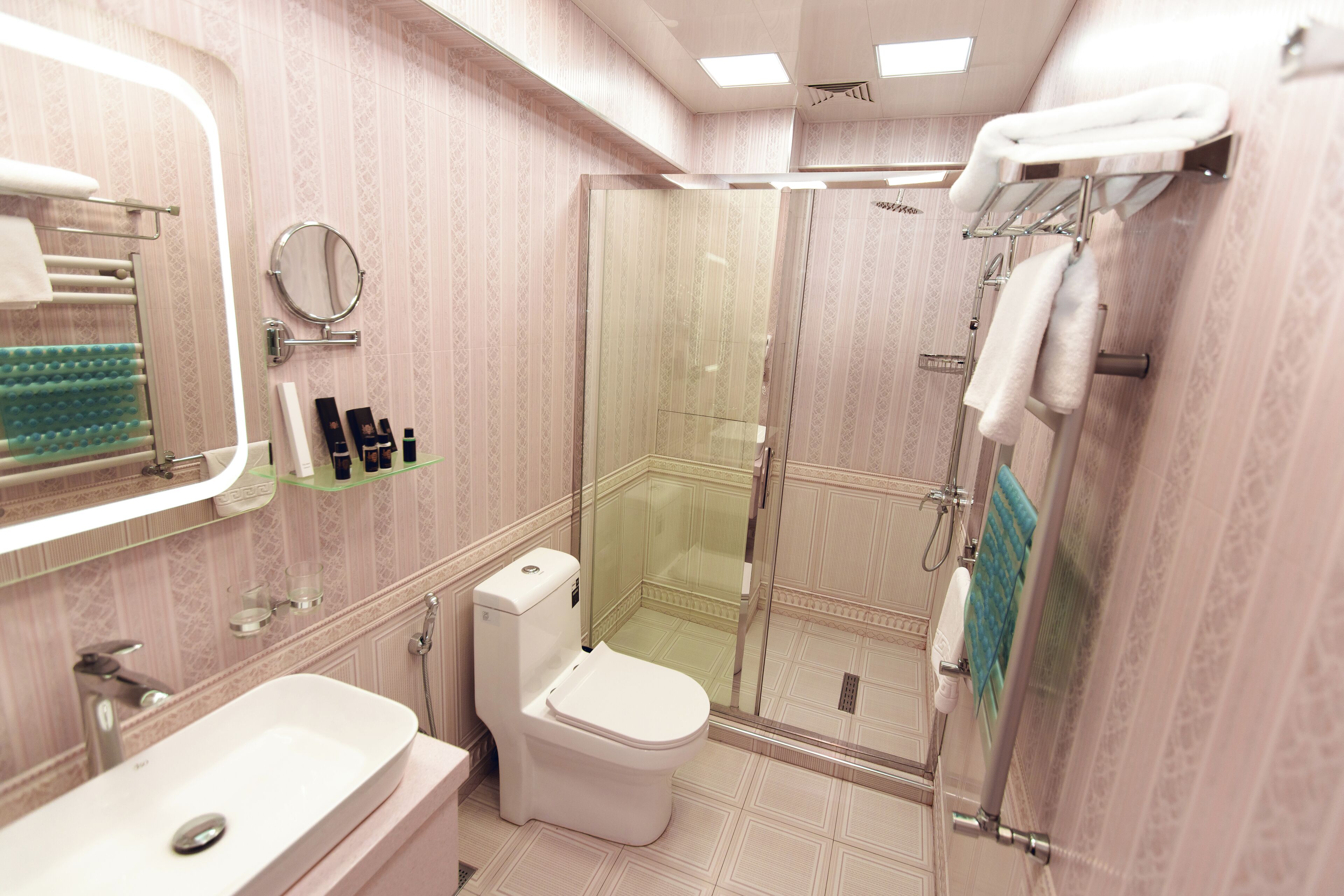 Un baño con inodoro, lavamanos y zona de ducha.