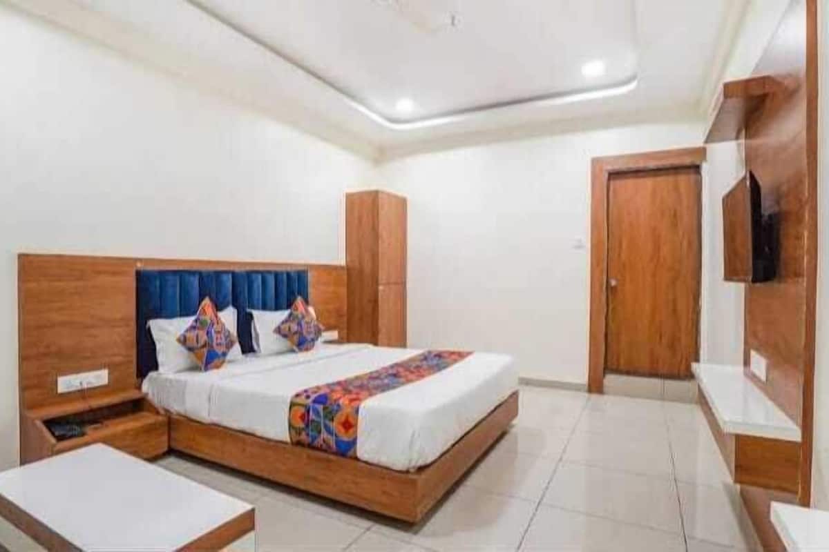 A bedroom with a bed, bedside tables, a wardrobe, and a TV.