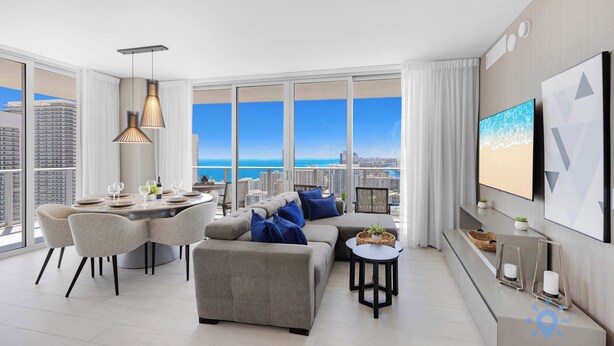 A modern living room with a dining area, large windows with a city view, and a flat-screen TV mounted on the wall. - Wrap Around Balcony + Pool + Steps to the Beach (Hollywood)