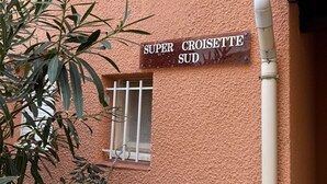 Een gebouw met een gestructureerde gevel en een bord waarop 'SUPER CROISETTE SUD' staat.