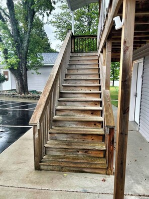 Un escalier en bois mène à une véranda couverte.