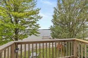 A wooden deck with a view of a lake, surrounded by trees. - Upper Level Lakeview Room (Lake City)