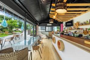 A modern café with a glass dining area, wooden furniture, and a bar counter with various items. - Metiyuan (Nanzhuang)