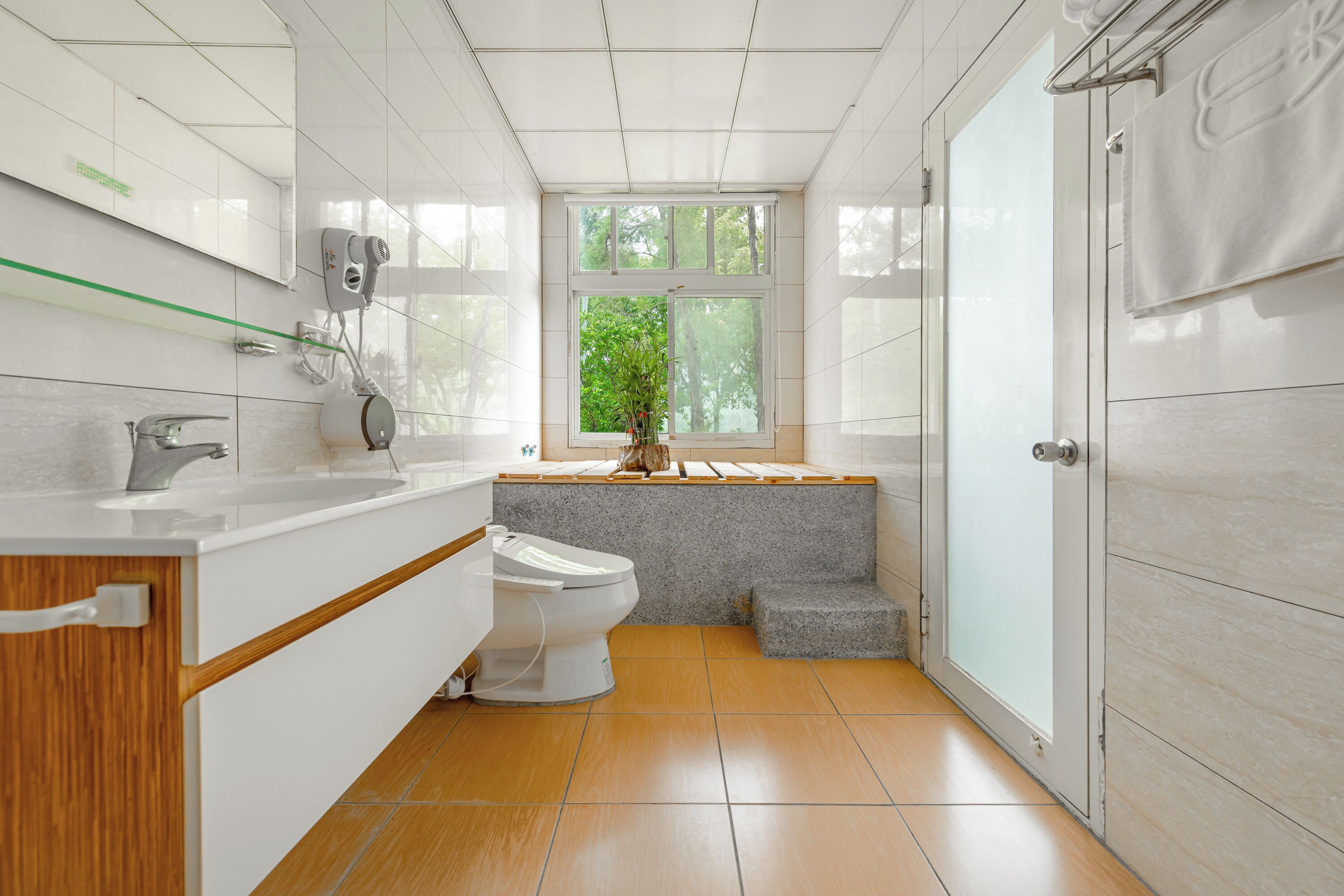 Un baño moderno con inodoro, lavabo y ventana.
