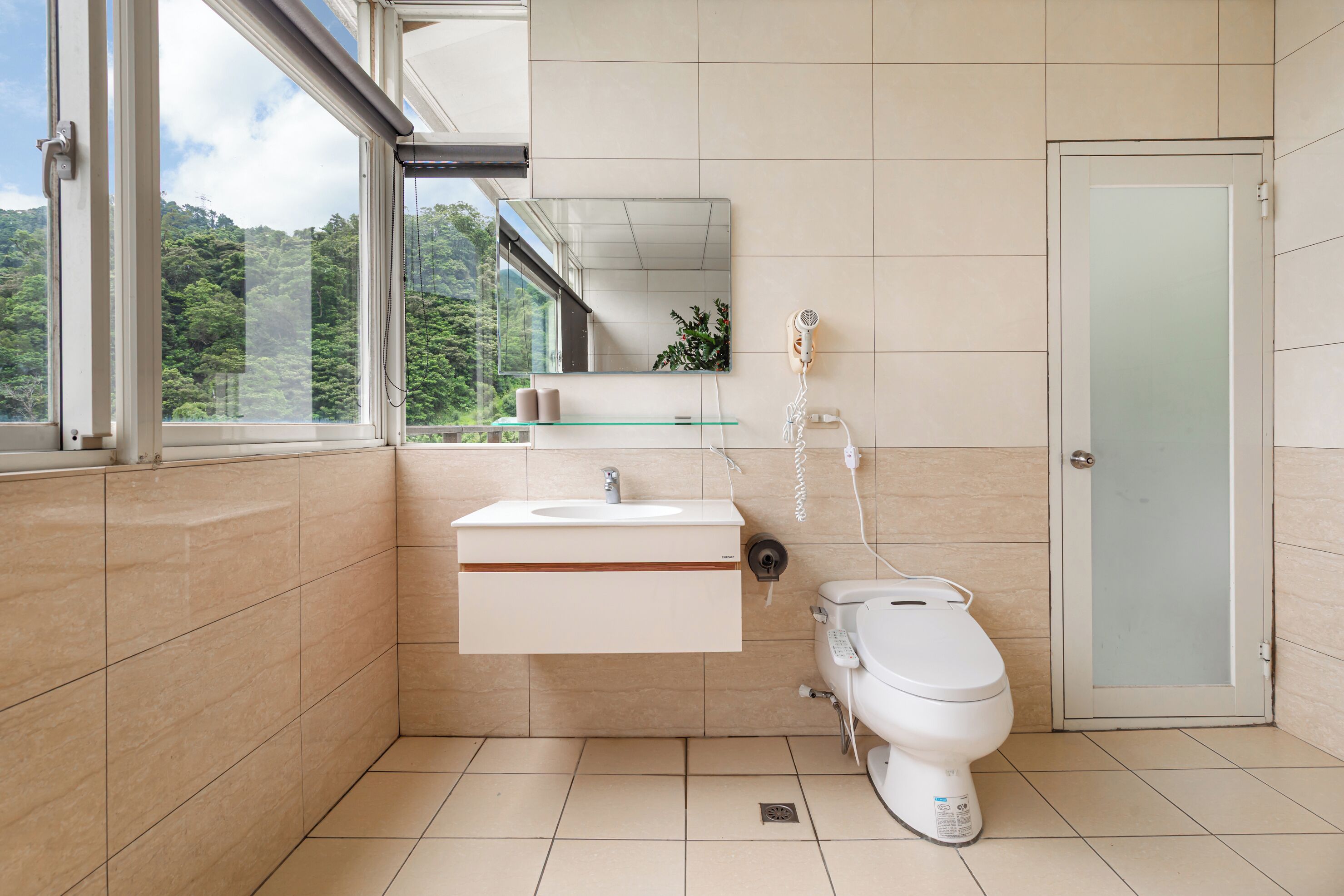 Ein modernes Badezimmer mit Waschbecken aus Glas, Toilette und Dusche.