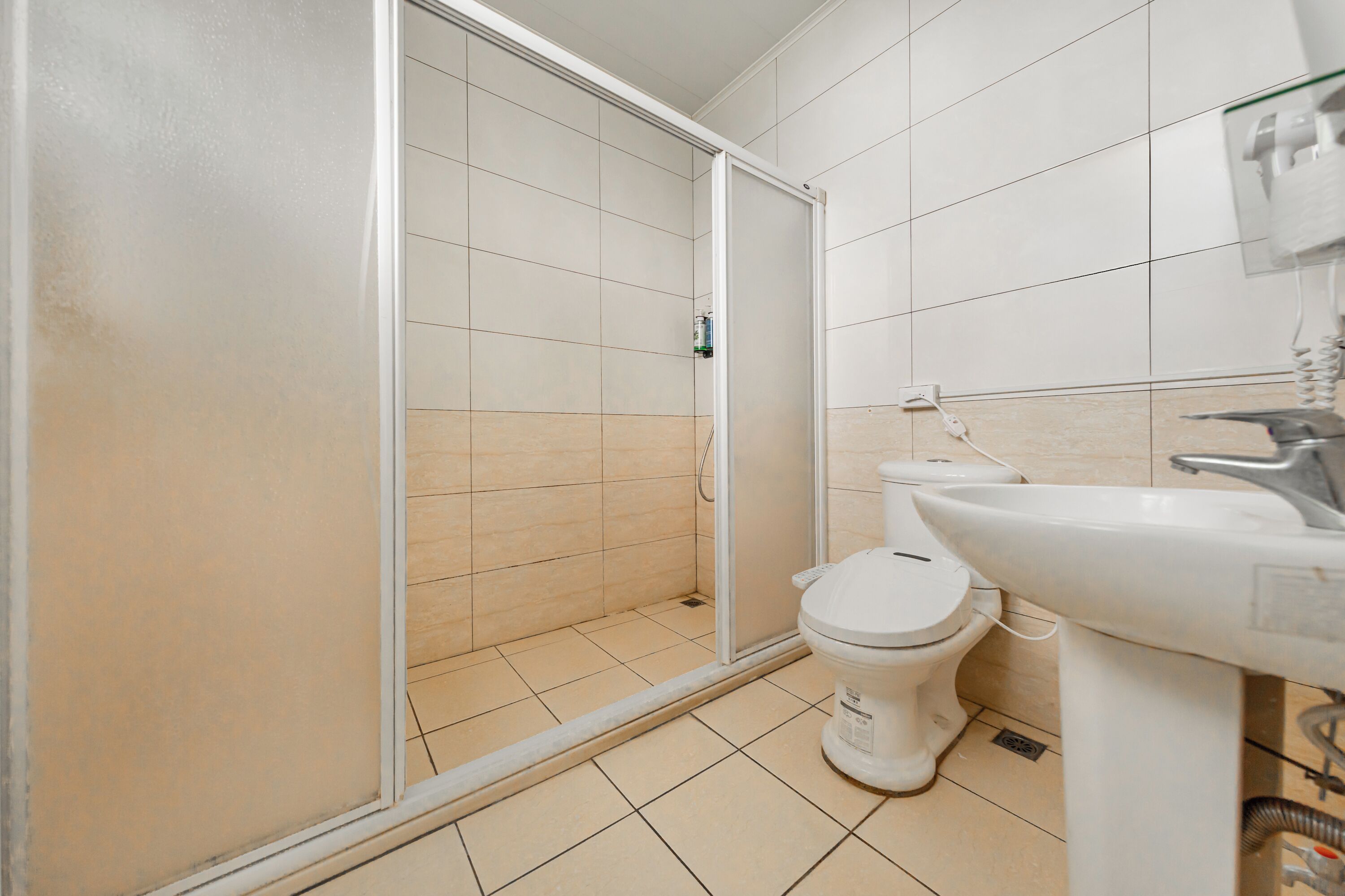 A bathroom with a shower, toilet, and sink.