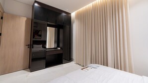 Ein modernes Schlafzimmer mit Bett, Einbauschrank und großem Spiegel.