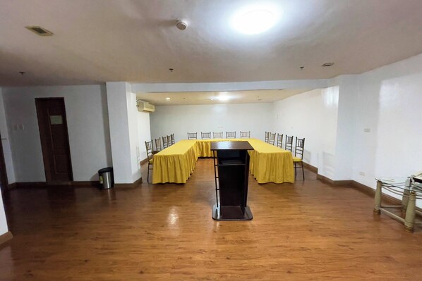 A conference room with a long table, chairs, and a podium.