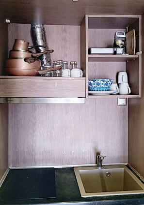 A compact kitchen with a sink, a stove, and a small countertop.