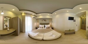 Une chambre d’hôtel moderne avec un lit aux lignes courbes, une coiffeuse avec un miroir, une décoration sur le thème du vélo et un téléviseur fixé au mur.