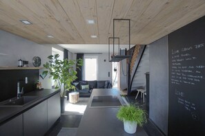 Eine moderne Küche mit schwarzem Arbeitsplatz, einem Spülbecken und einer Uhr an der Wand.