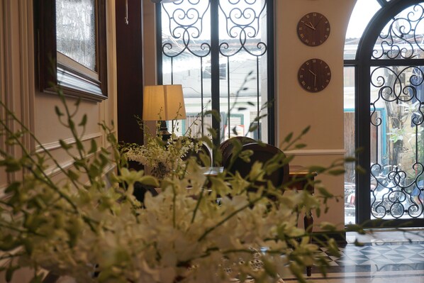 A room with a large window, a lamp, and two wall clocks. - Jade Boutique Hotel (Hanoi)