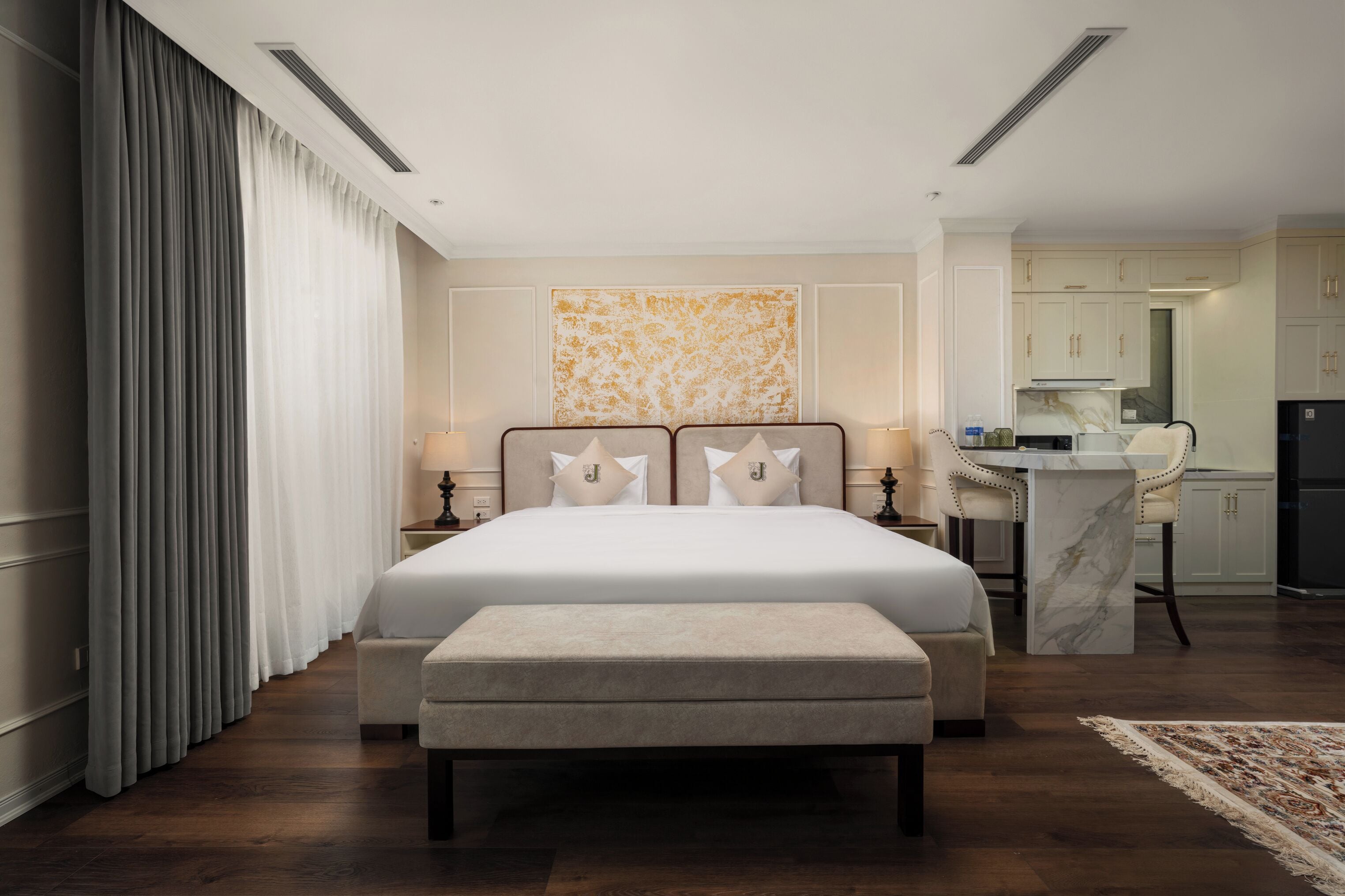 Una habitación de hotel con una cama grande, un escritorio y una kitchenette.