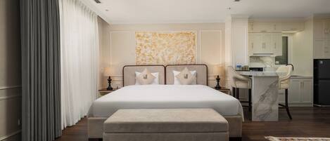 Una habitación de hotel con una cama grande, un escritorio y una kitchenette.