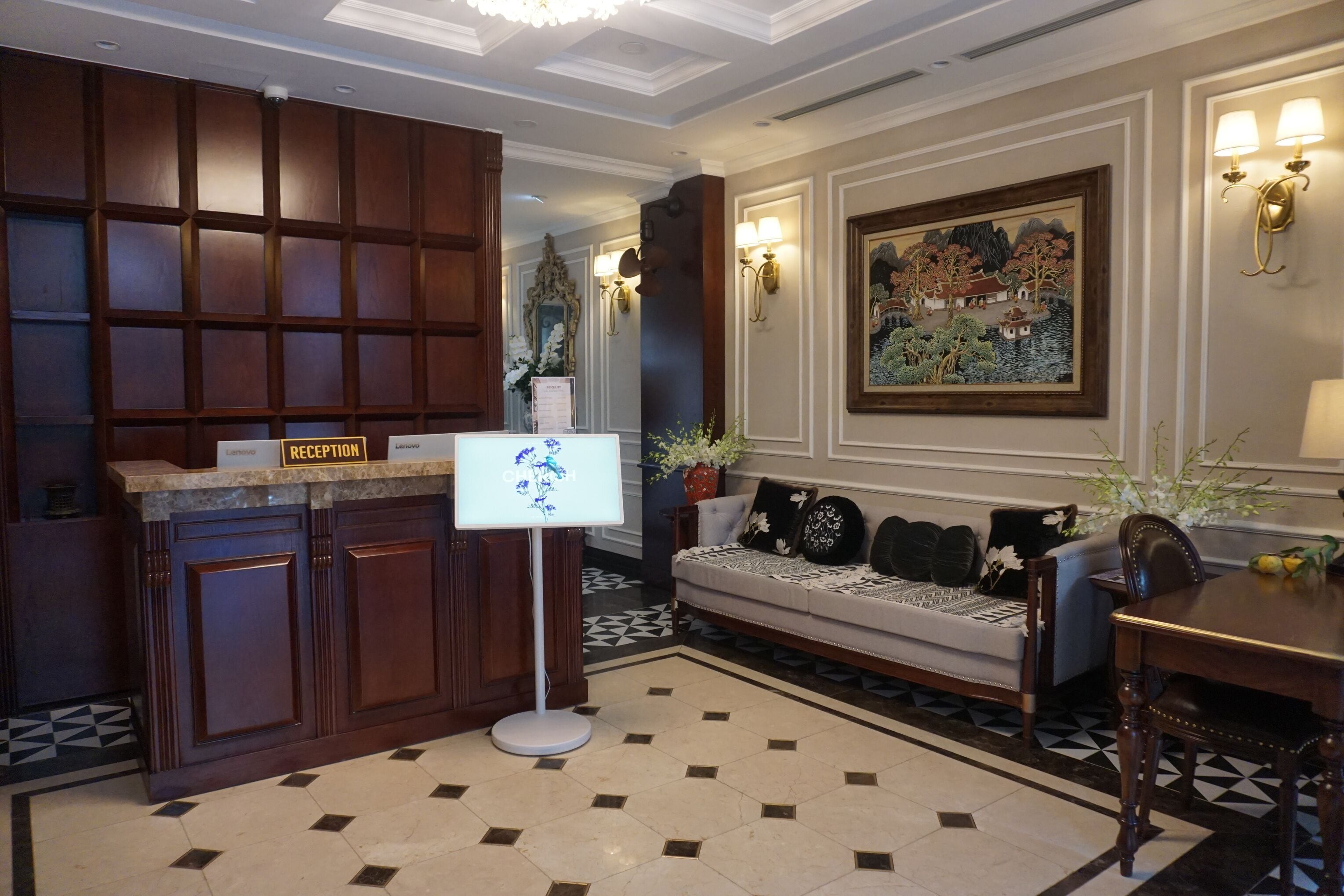 A reception area with a reception desk, a sofa, and a dining table.