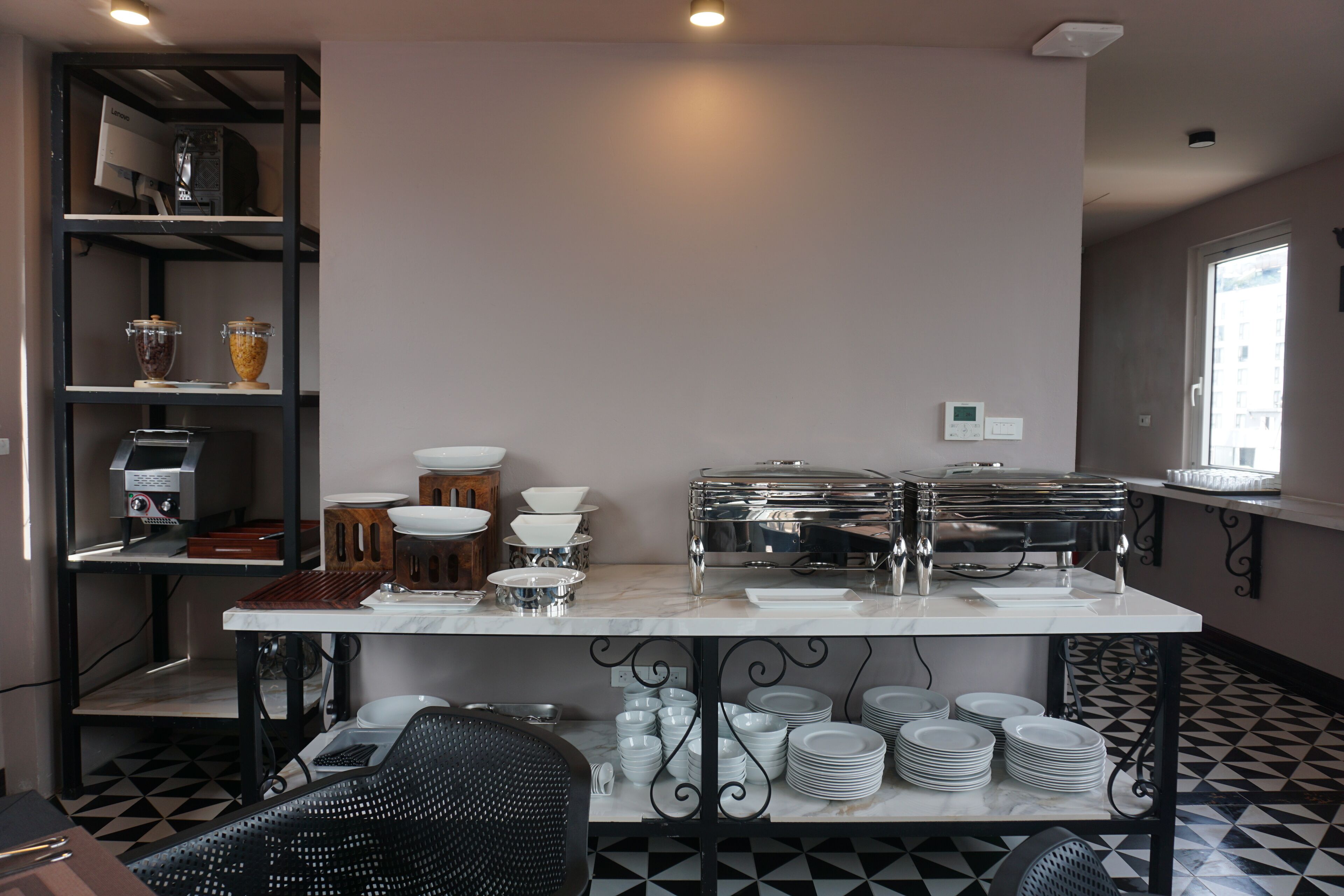 A buffet setup with various food containers and serving dishes on a marble table.