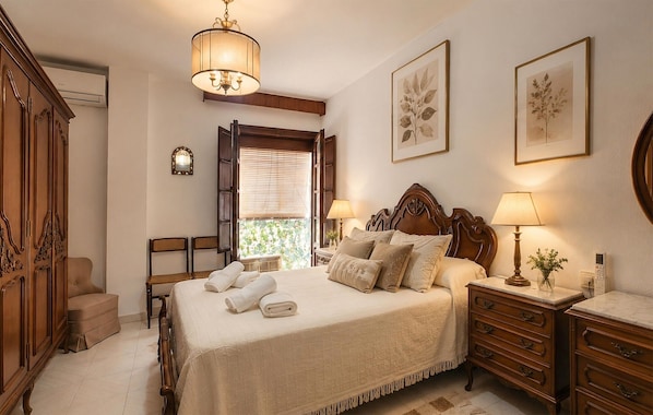 A bedroom with a bed, bedside tables, a wardrobe, and a window with blinds.