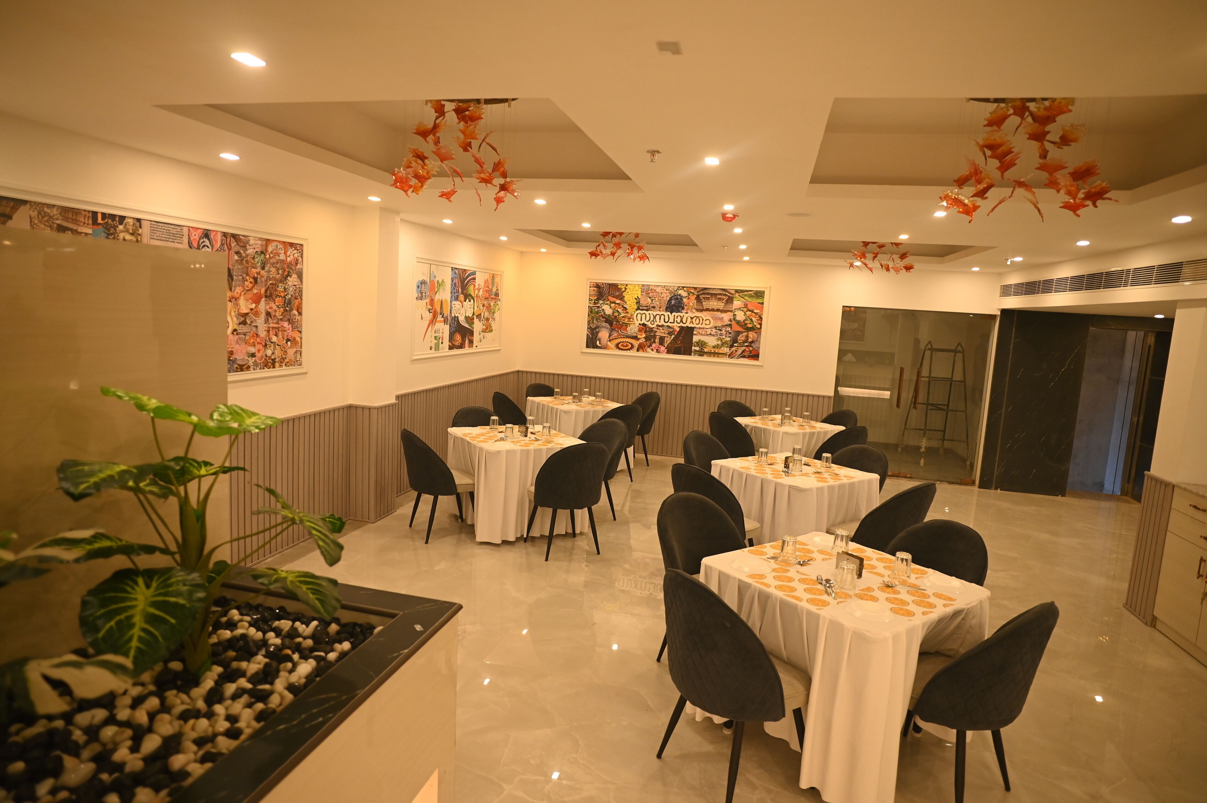 A restaurant with round tables, black chairs, and a decorative ceiling.