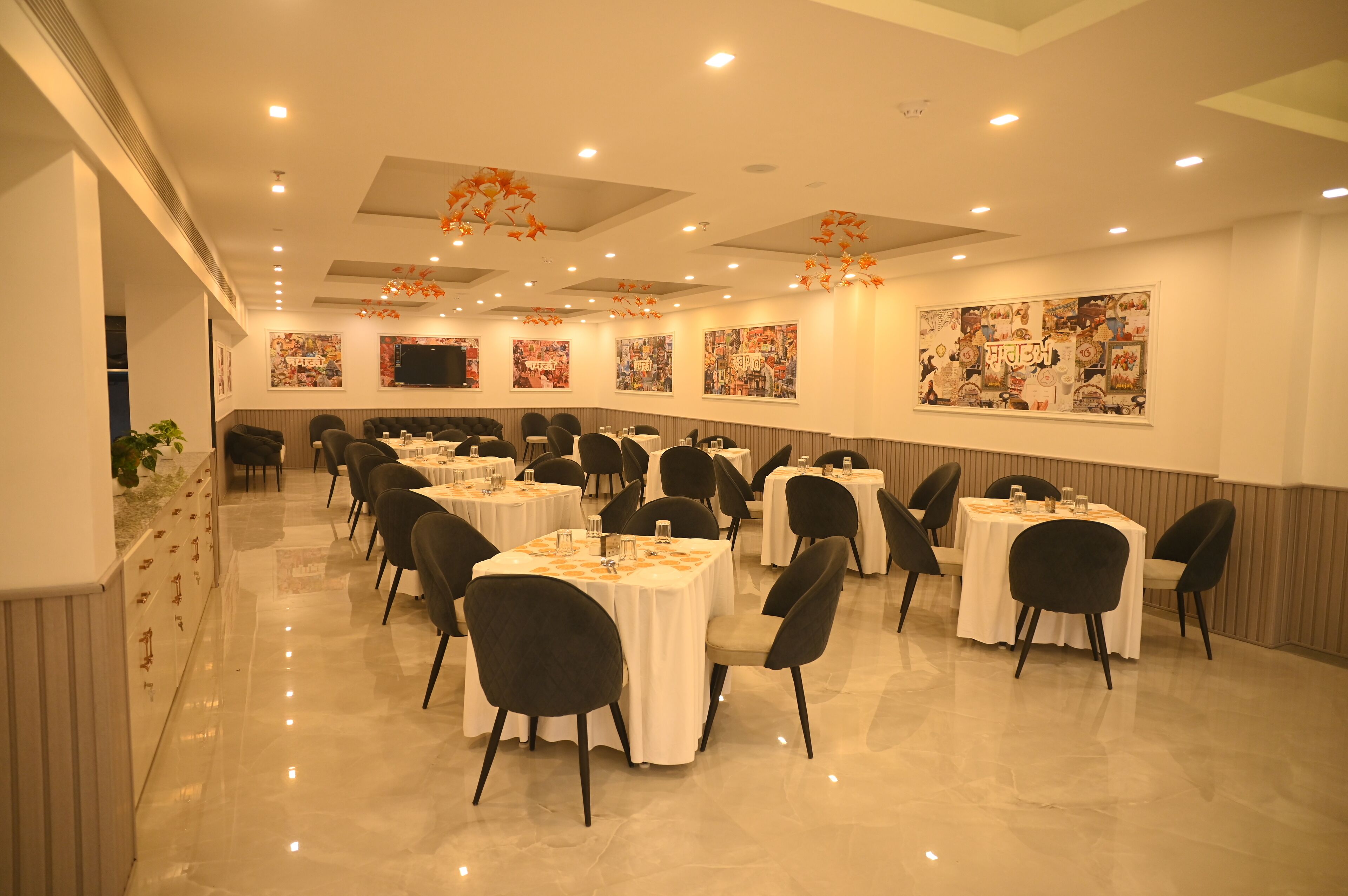 Un amplio salón de banquetes con varias mesas redondas, sillas negras y manteles blancos.