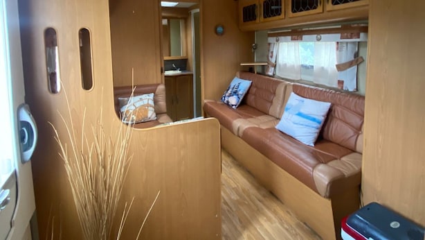 A compact RV interior with a kitchenette, a seating area, and a compact storage unit. - Cozy caravan in beautiful Tornio with AC (Lappi)