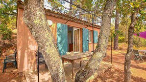 A rustic cabin with a wooden table and chairs, surrounded by trees. - 2 bedroom lovely home in Villars (Villars)