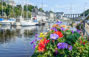 A marina with boats docked, a bridge in the background, and colorful flowers along the water's edge. - Awesome home in Landivisiau with sauna (Landivisiau)