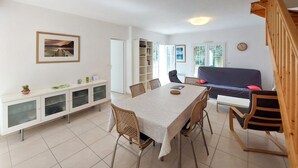 Un rincón comedor con una mesa, sillas, un sofá y una estantería.
