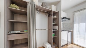 A modern kitchen with wooden shelves, a white countertop, and a small stool. - Studio '4' with Private Terrace, Shared Garden, SPA and Wi-Fi (Hanvec)