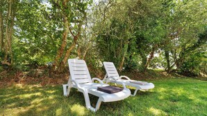 Two white lounge chairs with towels placed on them, set on a grassy lawn surrounded by trees. - Studio '4' with Private Terrace, Shared Garden, SPA and Wi-Fi (Hanvec)