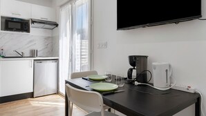 A modern kitchen with a built-in microwave, a coffee maker, and a dining table with chairs. - Studio '4' with Private Terrace, Shared Garden, SPA and Wi-Fi (Hanvec)