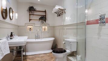 A bathroom with a freestanding bathtub, a toilet, and a glass-enclosed shower area.
